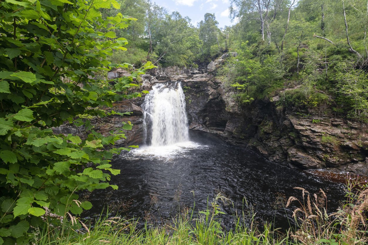 View through foliage of the Falls of Falloch in Scotland