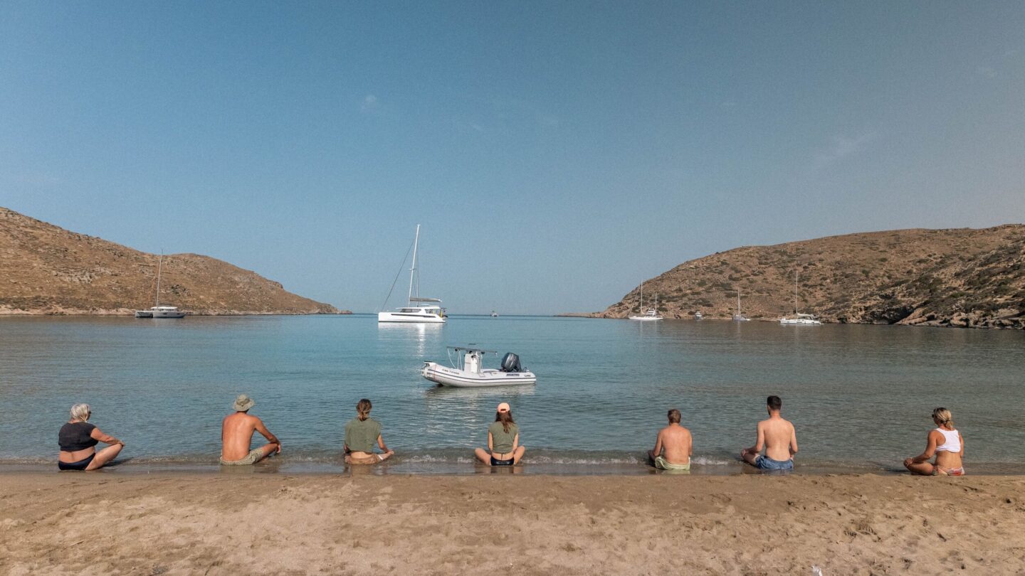 Freediving group meditating on Kolona beach in Greece
