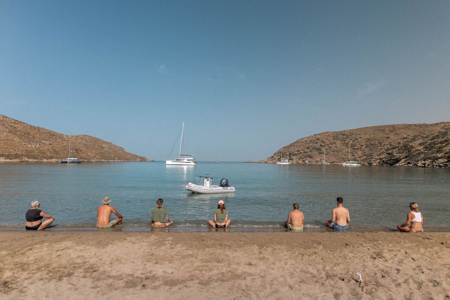 Freediving group meditating on Kolona beach in Greece