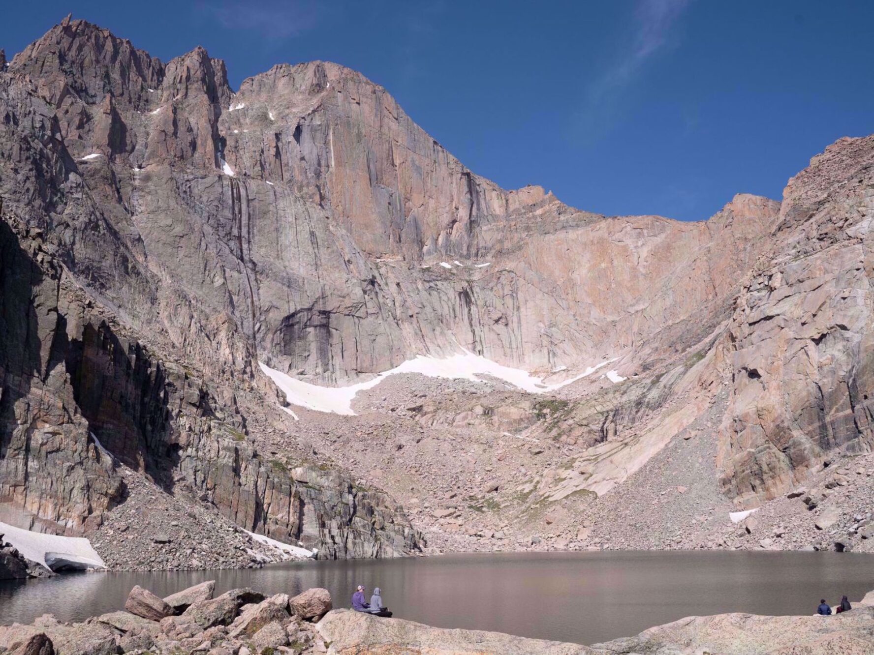 Hikers sitting next to Chasm Lake on the Rocky Mountain National Park women trip