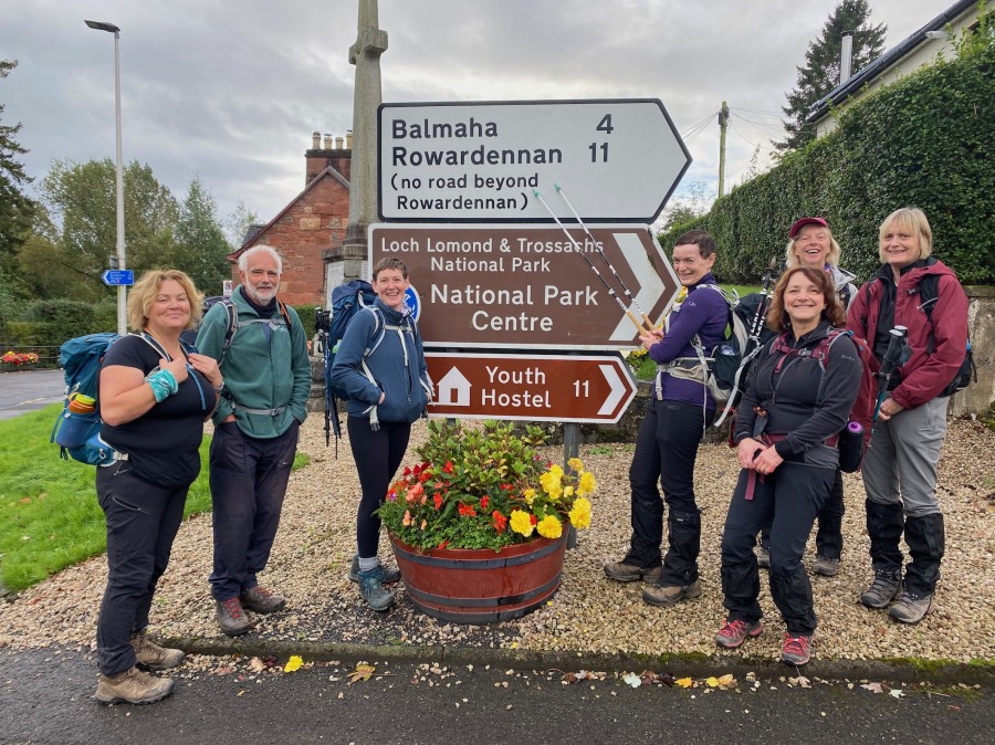 Hikers near a signpost in Rowardennan on the West Highland Way tour