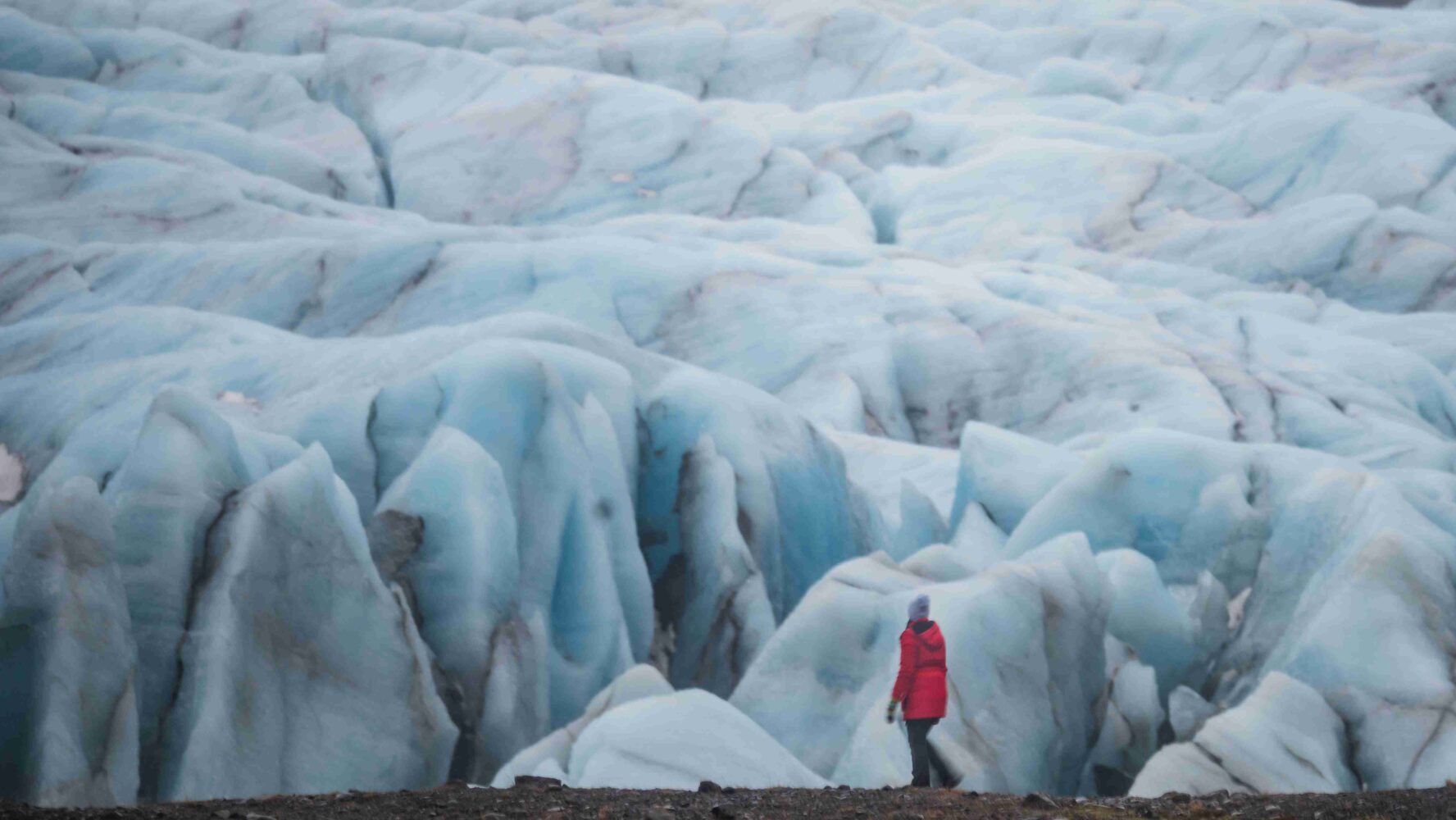A hiker near a glacier in Black Beach, Iceland