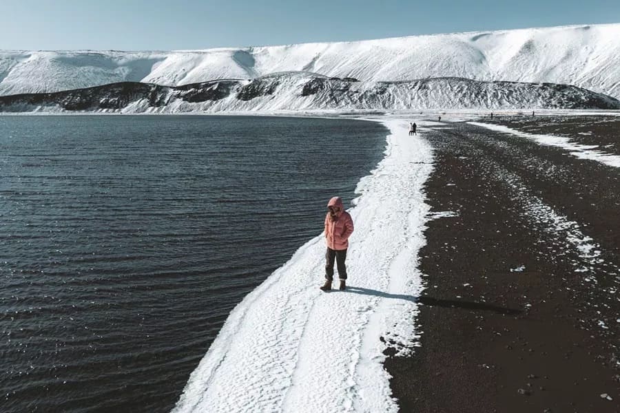 Man walking by Kryusvik lake, shore