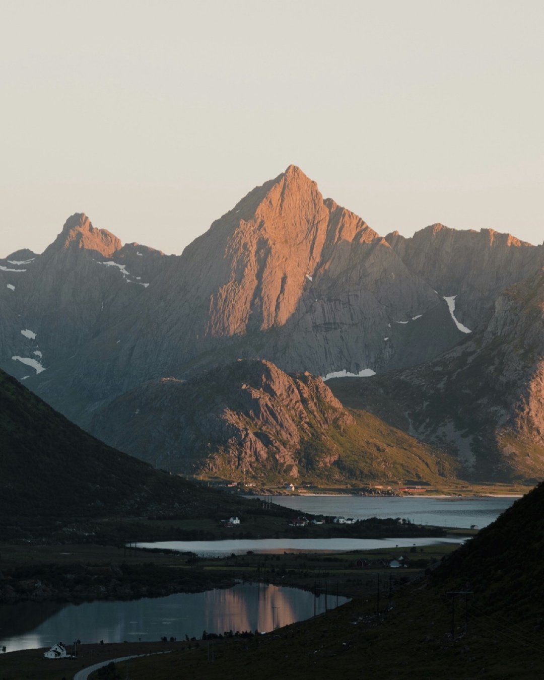 A sunlit mountain and fjord while sailing Lofoten