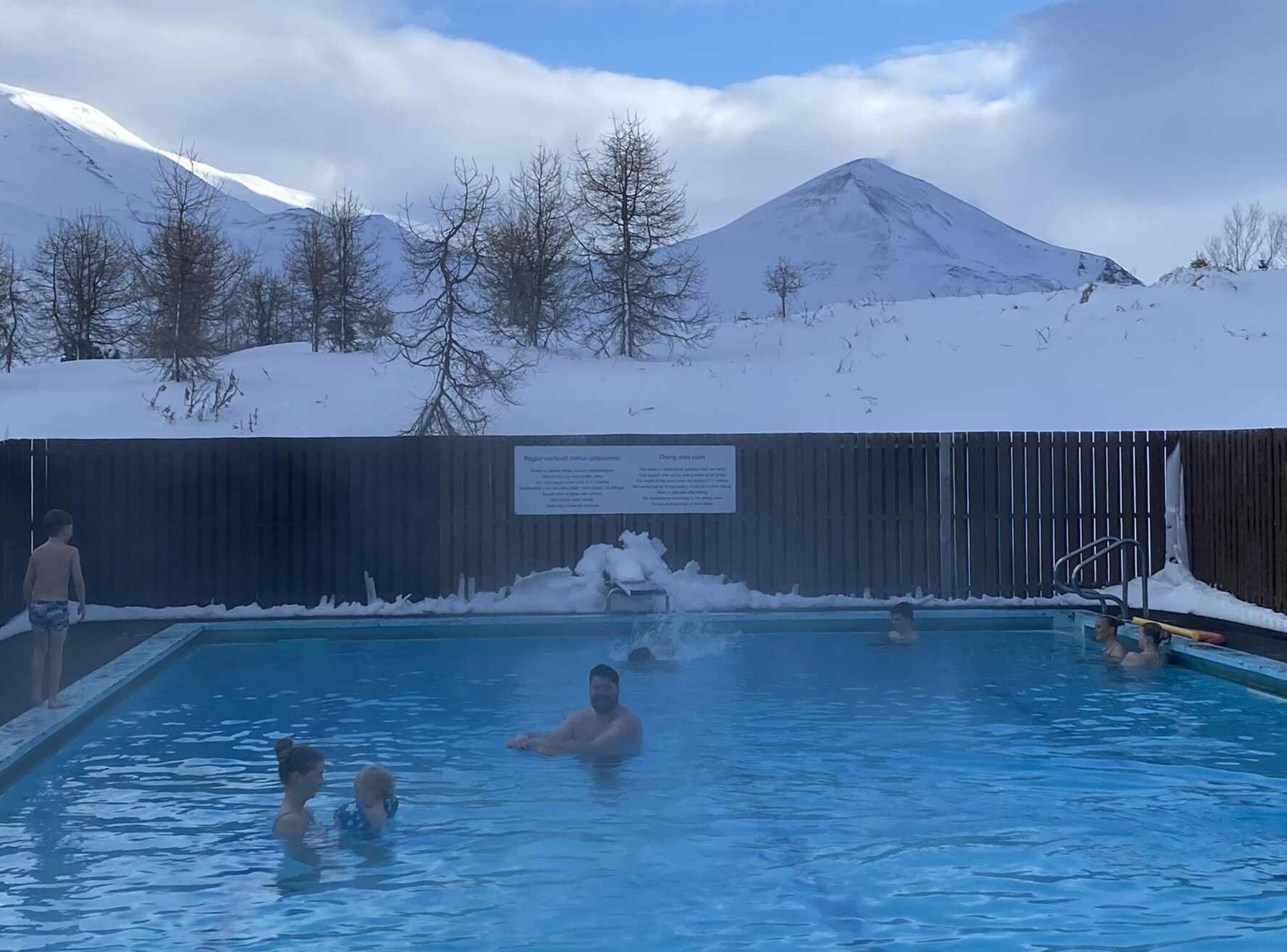 People relaxing in the geothermal pool with a view of the mountains of North Iceland