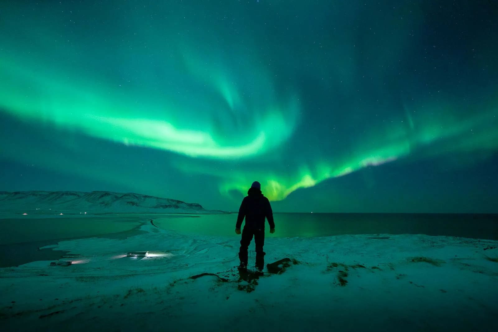 Skier admiring the Northern Lights in North Iceland