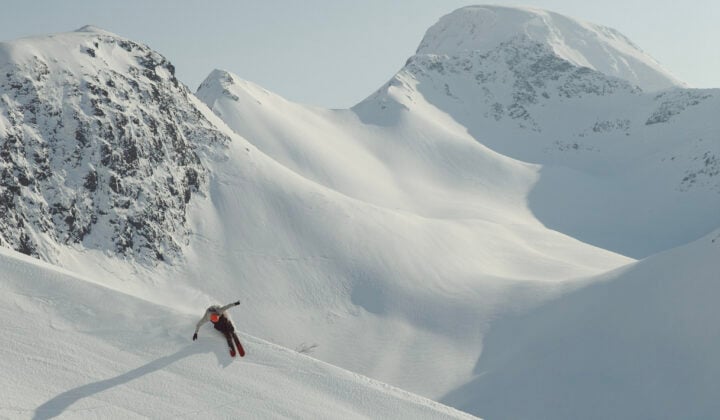 Skier carving through a snowy landscape in Lofoten