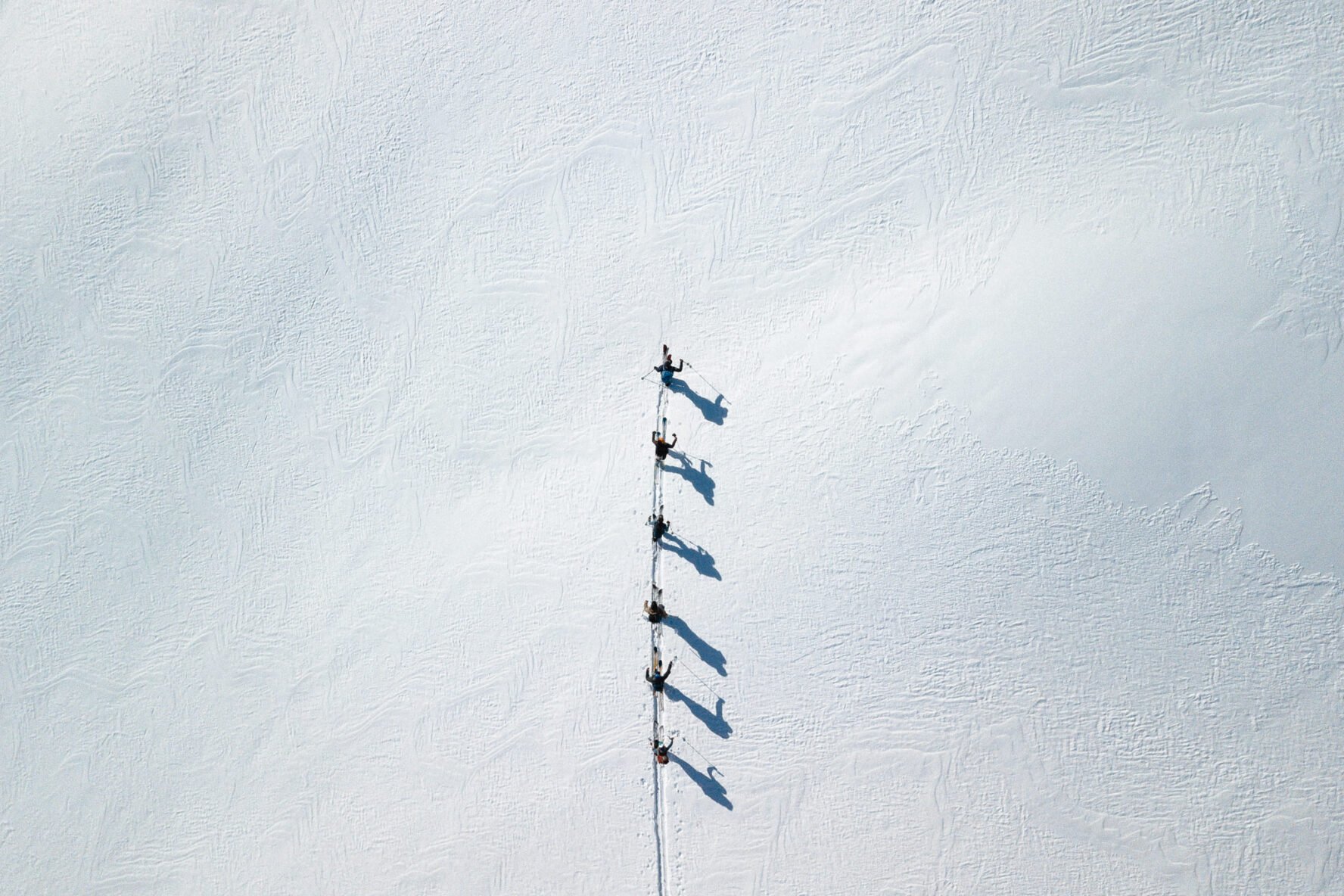 Aerial shot of skiers ski touring while sailing Lofoten
