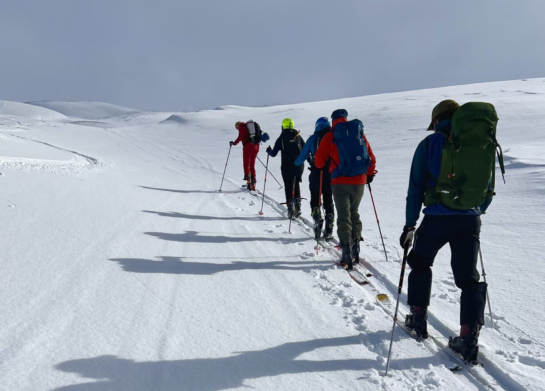 Skiers skinning up untouched snow during backcountry skiing, North Iceland