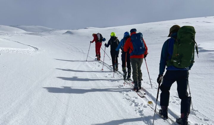 Skiers skinning up untouched snow during backcountry skiing, North Iceland