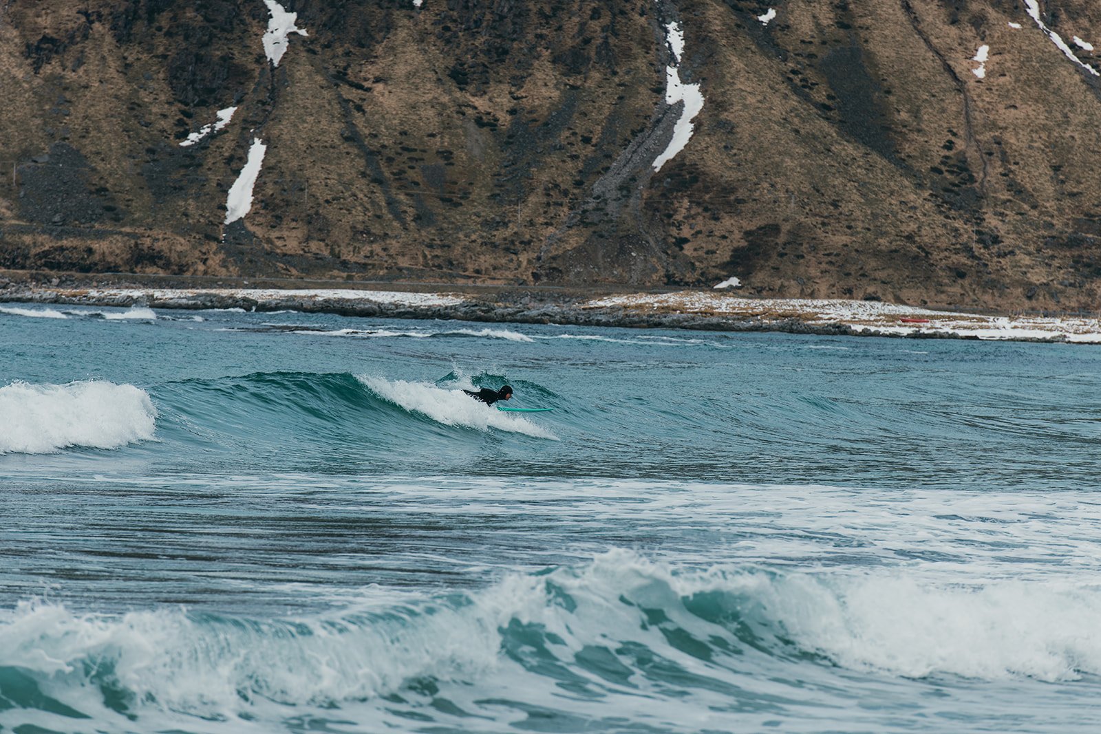 Surfer on a wave in Lofoten