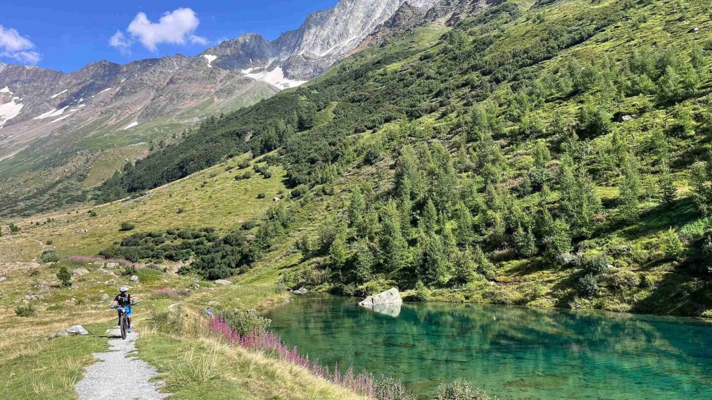 A bike rider near a lake in the Swiss Valais
