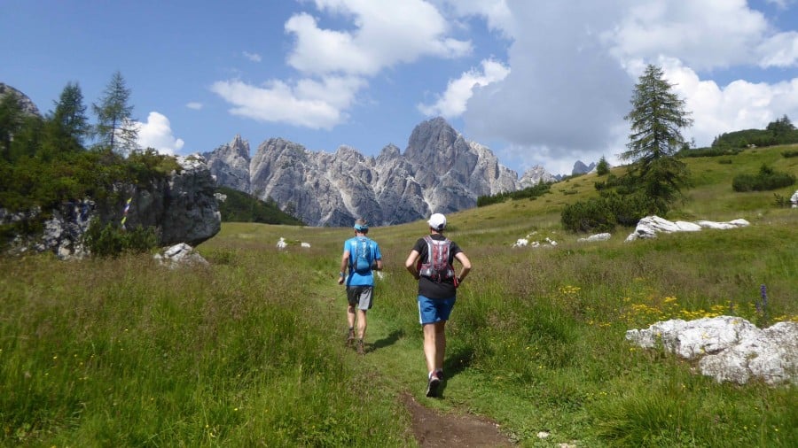 Trail runners on a path towards the mountains on the Alta Via 1 trail run