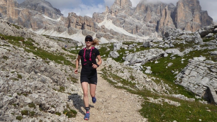 Woman trail running with mountains in the background on the Alta Via 1 trail run