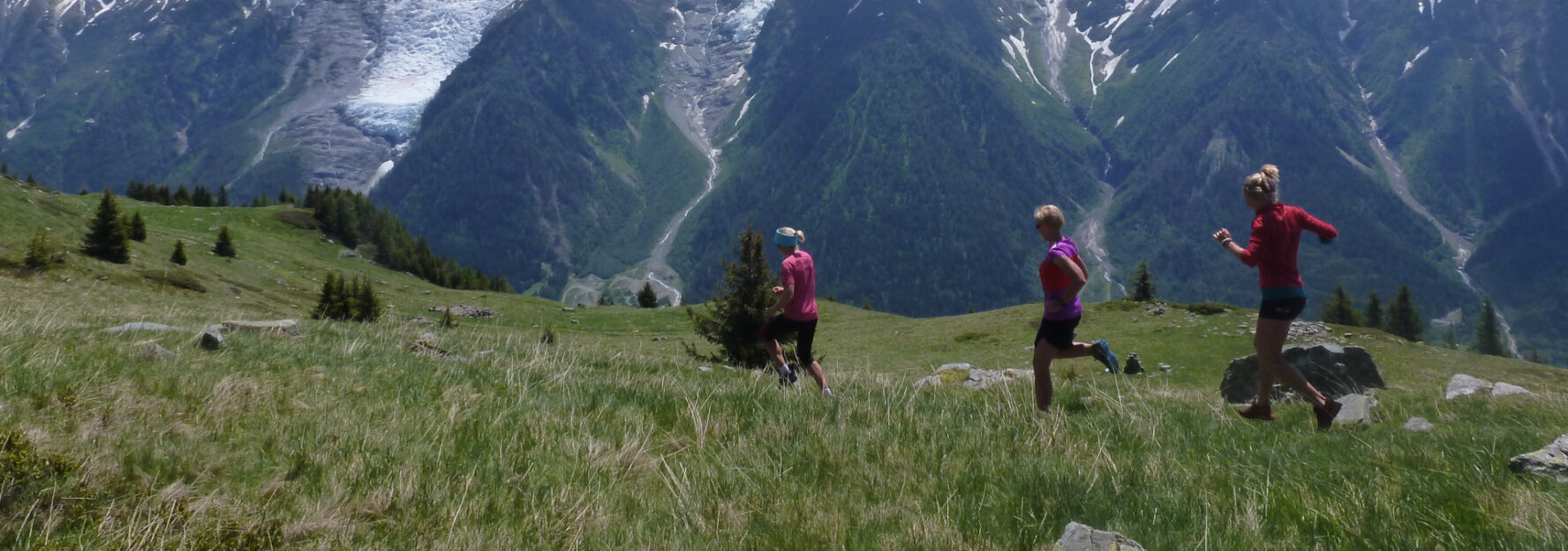 Three trail runners on a green path in the Chamonix area