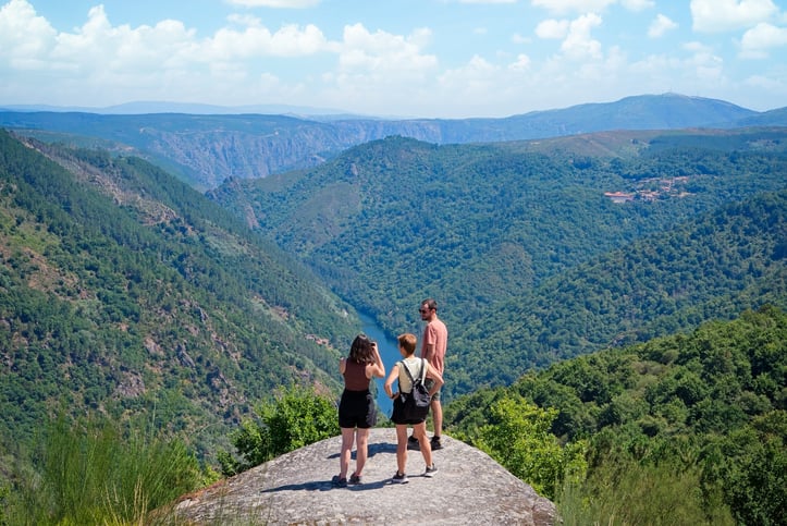 Hikers on a rock along the Camino Primitivo, Spain