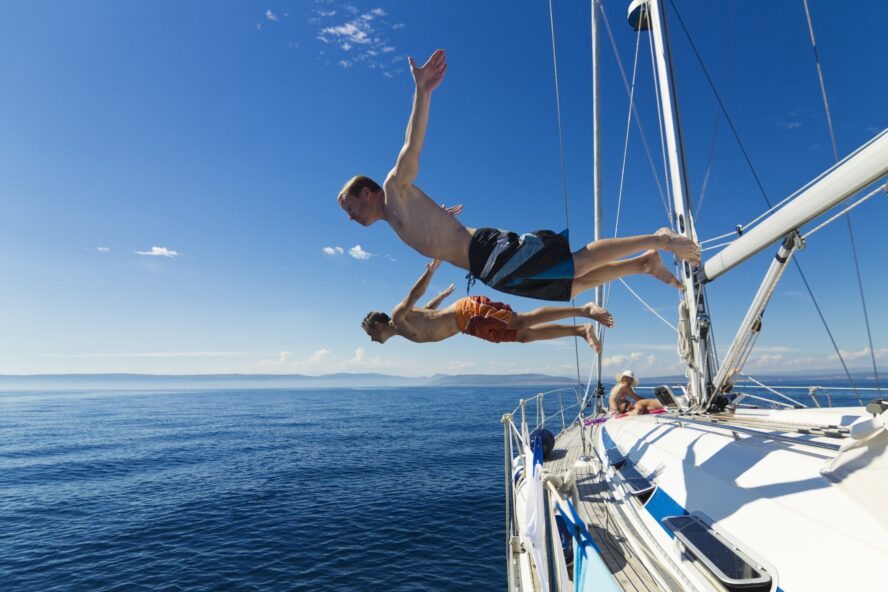 People jumping head first from a Charter Sailboat in Croatia admiring the nature