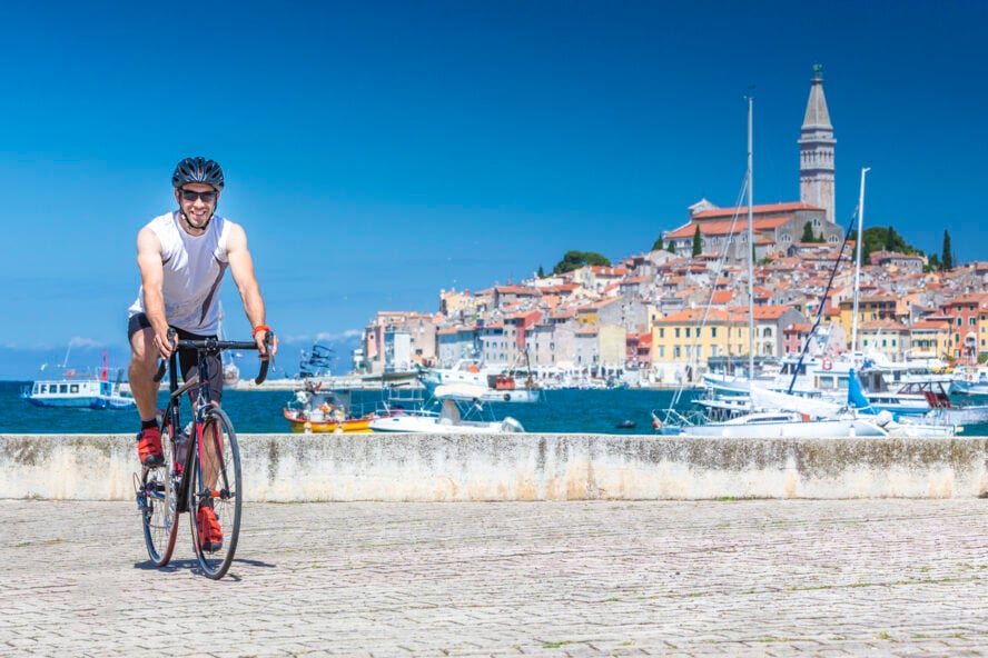 Man On Bicycle By Sea Against Sky in Rovinj, Croatia