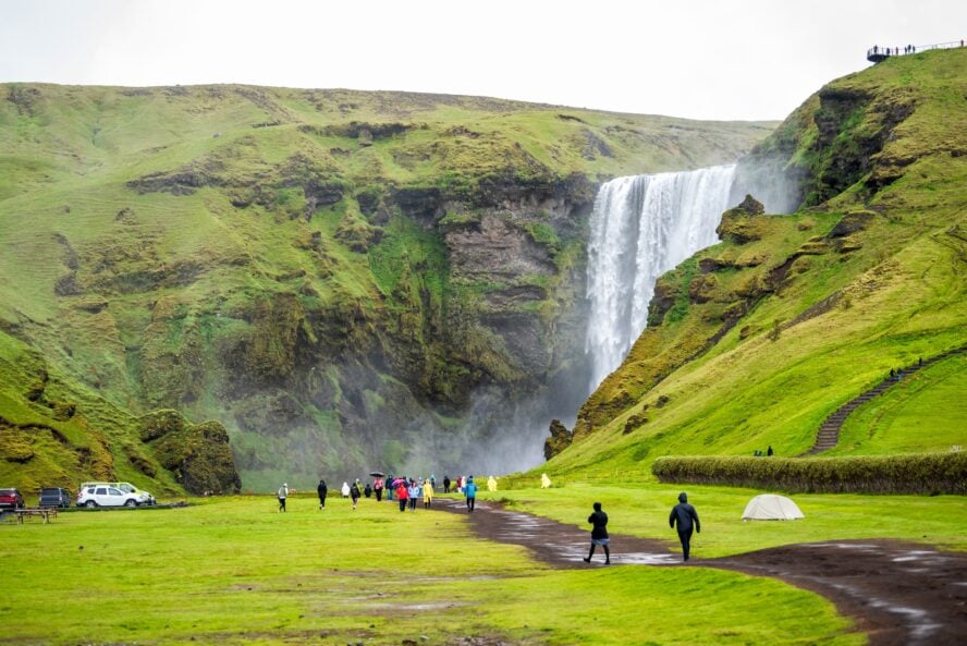 Hikers along a Ring Road itinerary on Skogafoss waterfall