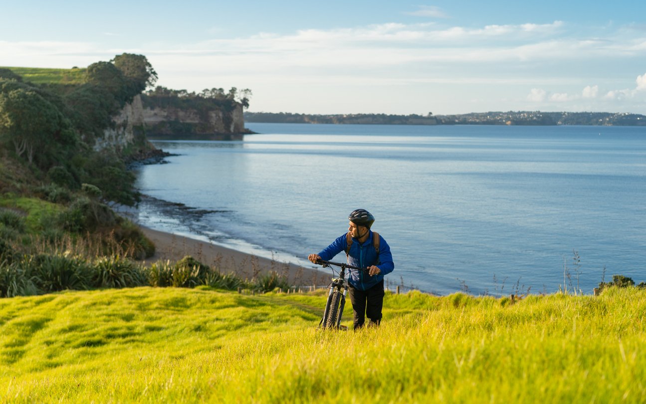 Bike rider enjoying a view while climbing on hill in Auckland, New Zealand.
