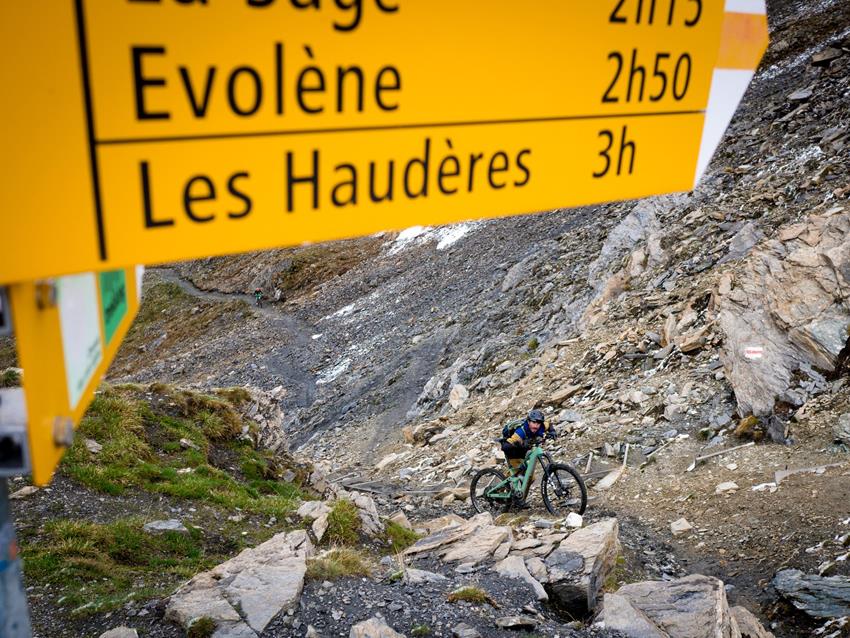 Pushing a bike on a lofty mountain pass
