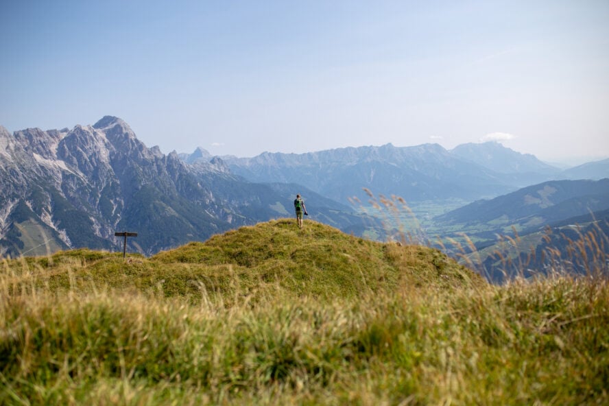 Hiker on a grass vista in the Dolomites, Italy, along the Alta Via 1