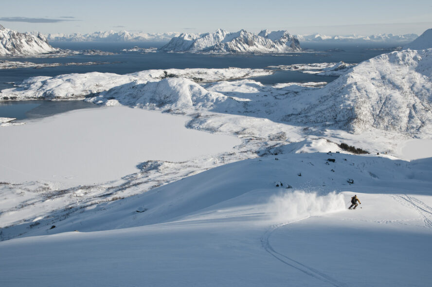 Skier skiing down mountains in Lofoten, Norway