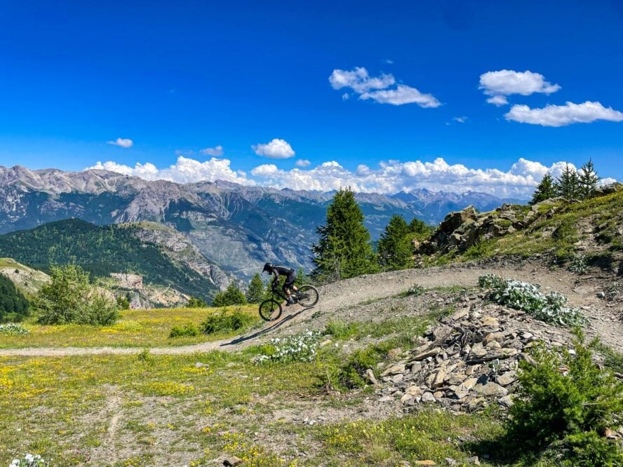 A cyclist biking on an alpine slope on a self-guided tour