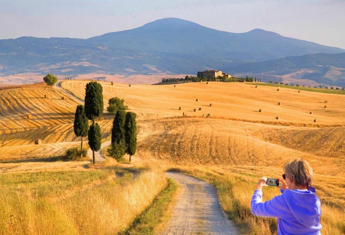 Female tourist photographing tuscany, italy, on one of the best solo trips for women