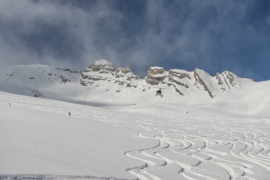 Helicopter in the mountains. freeride heliboarding in the Caucasus. Freeride snowboarding in winter. Heliboarding freeride. Riding in powder on snowborad. Freeride in Caucasus mountains.