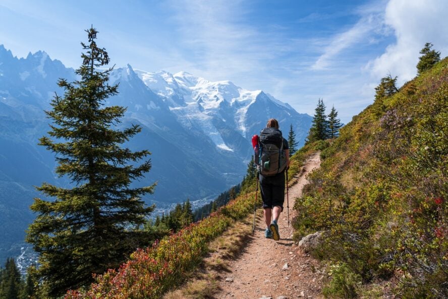 A hiker admiring what the landscape is on a self-guided tour of the Tour du Mont Blanc