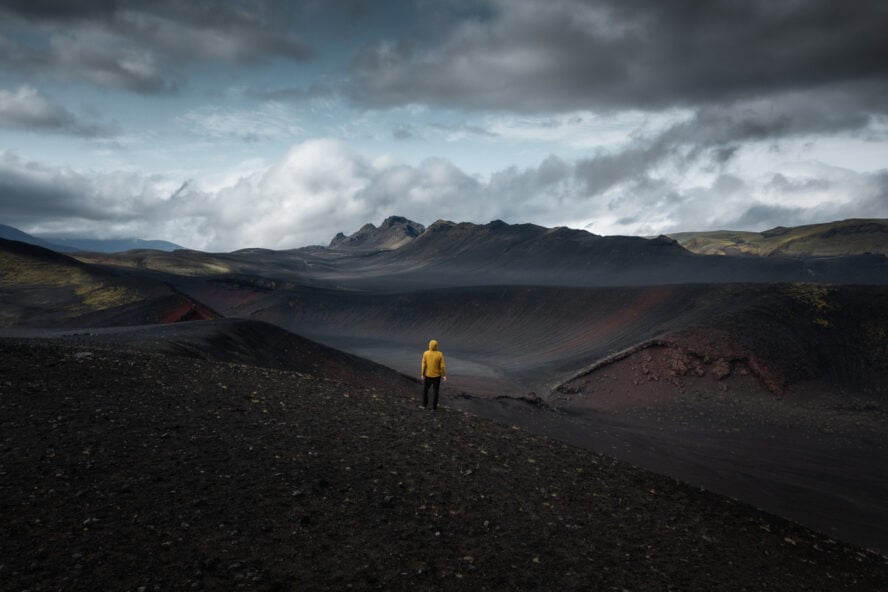 A hiker on top of a crater in Iceland admiring the view