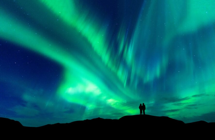 A silhouette of a couple admiring the northern lights in Iceland