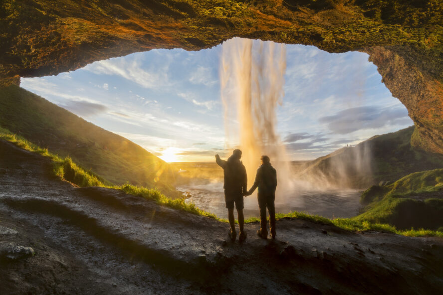 Hikers near an Iceland waterfall in the spring