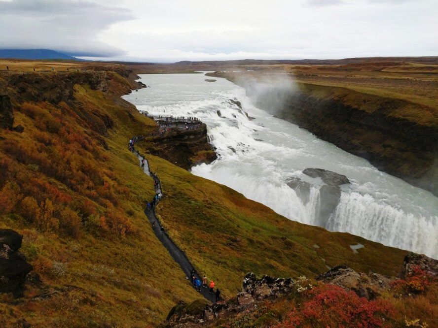 A waterfall and some hikers in Iceland in september