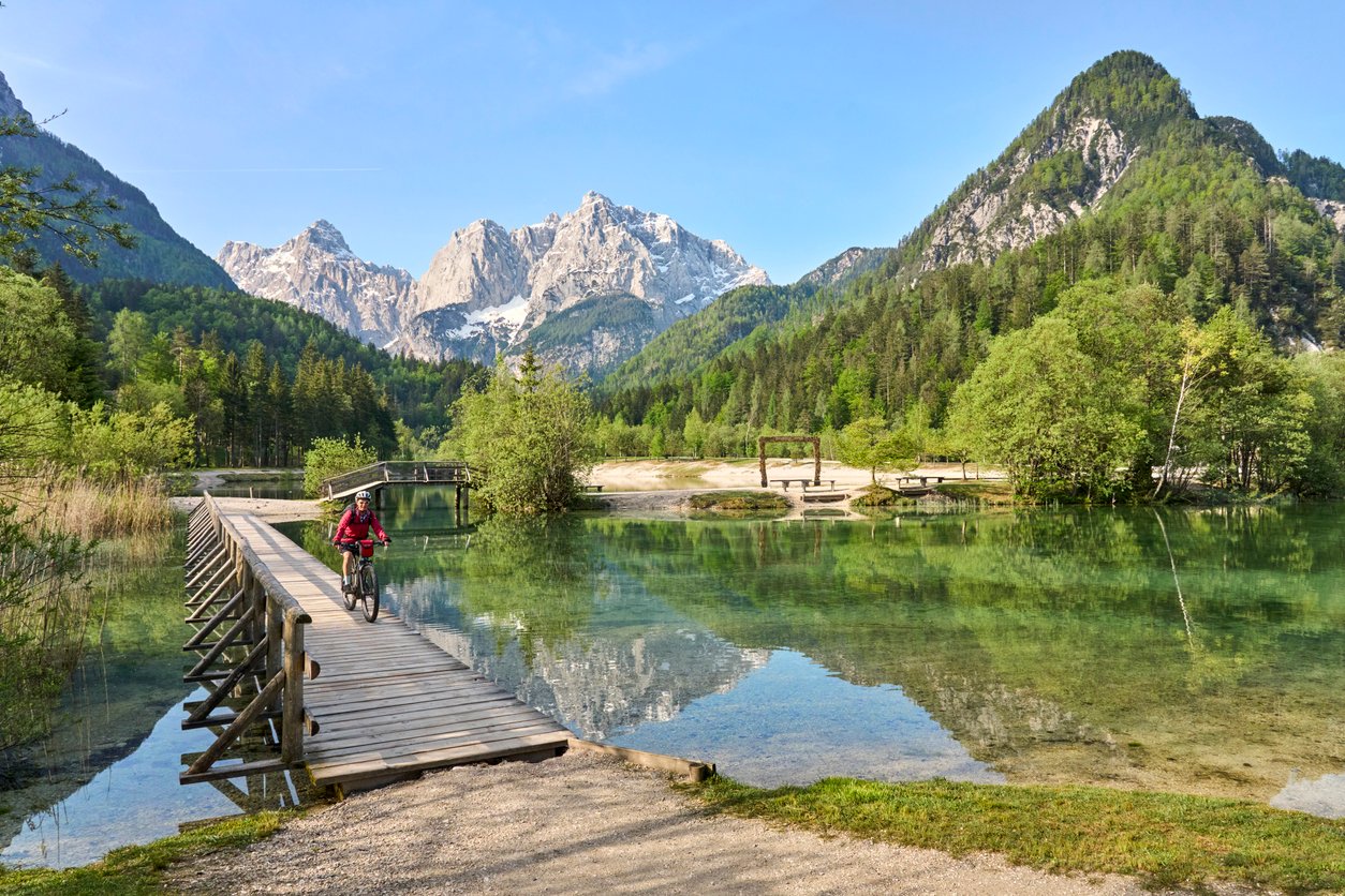 A woman cyclist crossing a bridge on a bike tour in the Julian Alps, Slovenia