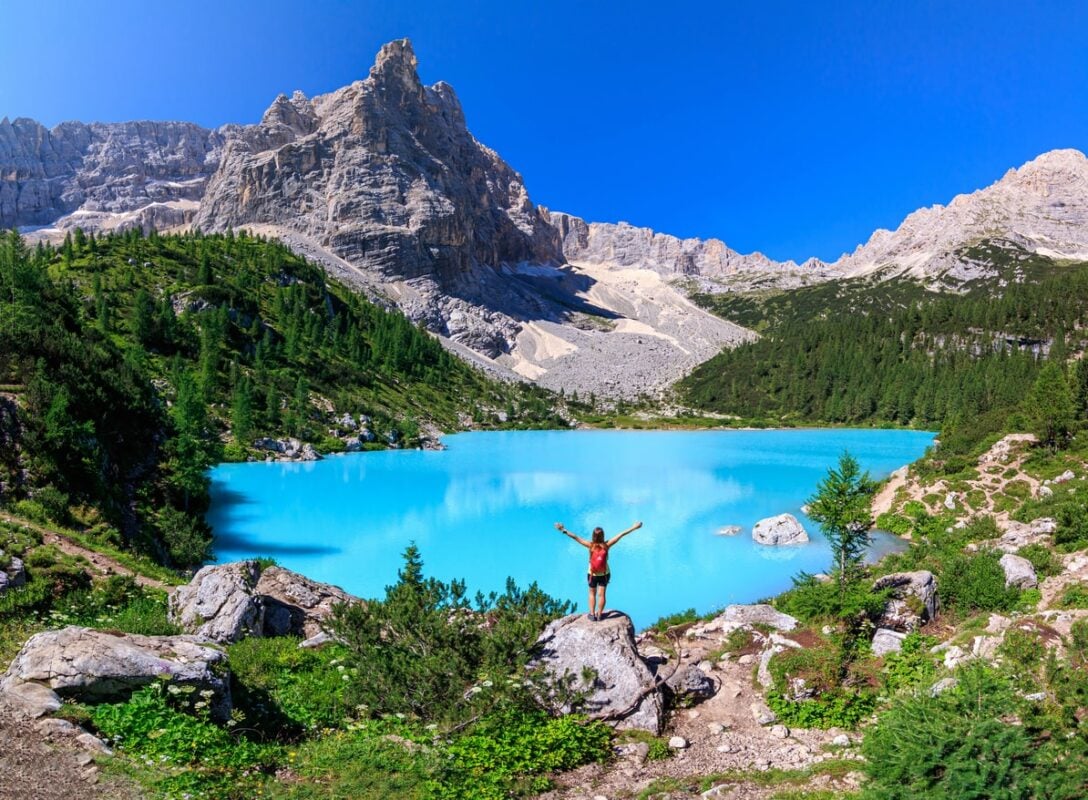 A hiker enjoying the view of Lago di Sorapis, Dolomites, Italy