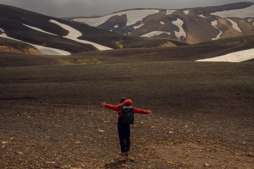 A hiker admiring the landscape with a full backpack in Landmannalaugar, Iceland