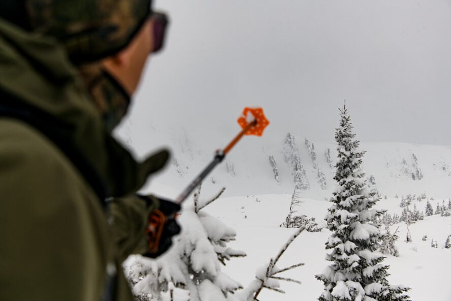 A man holding a ski touring pole in the backcountry