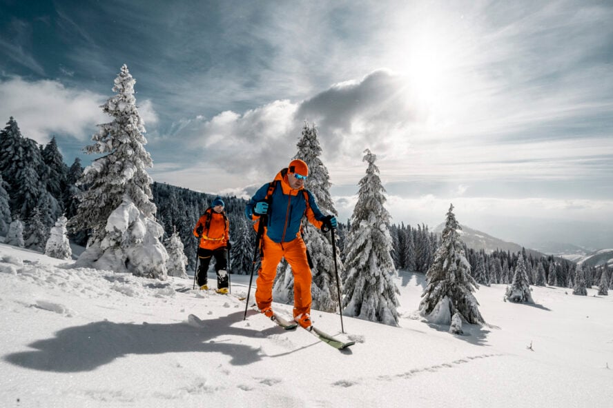Ski tourers showcasing colorful pants on a snowy slope
