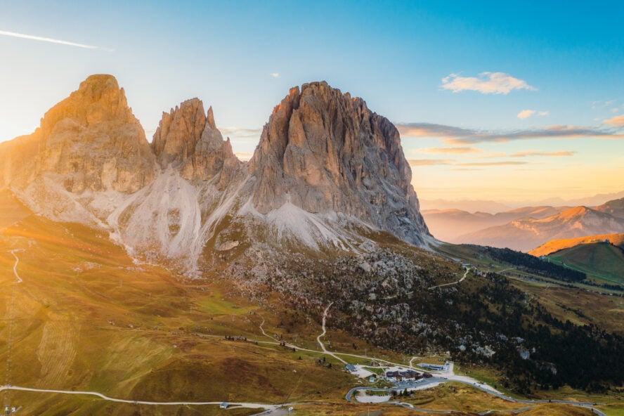 Aerial View of Paradise Sunset Over Mountain Layers and Hairpin Road of Sella Pass in Dolomites Alps, Val di Fassa, Italy