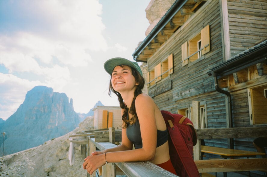 Happy woman relaxing on a porch after she found where to stay in the Dolomites