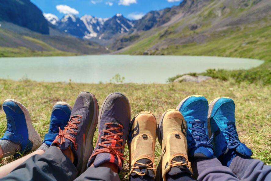 A family showcasing their hiking shoes in the mountains