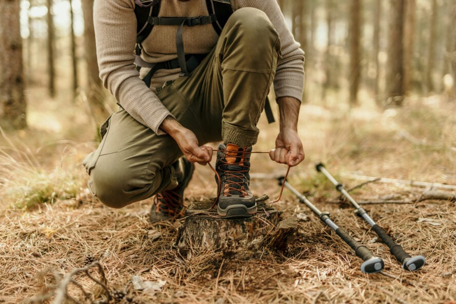 A hiker lacing his hiking boots that knows hot to break them in