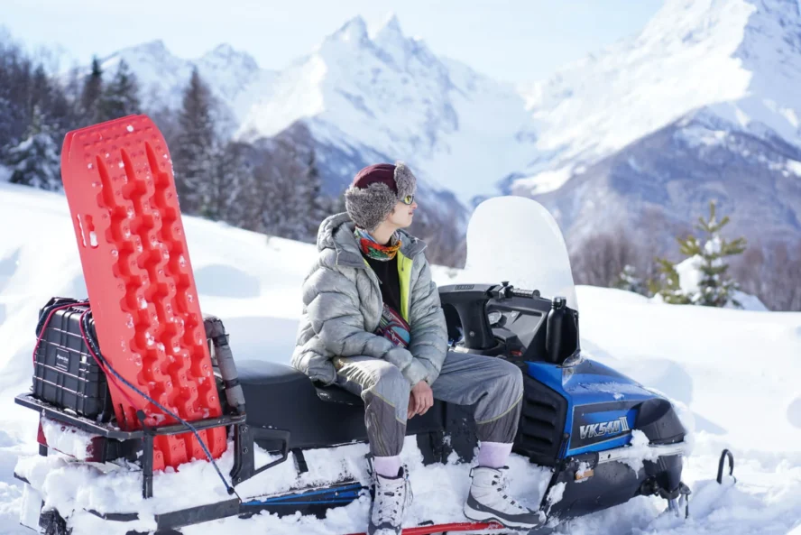 Backccountry skier and a snowmobile in Racha, Georgia