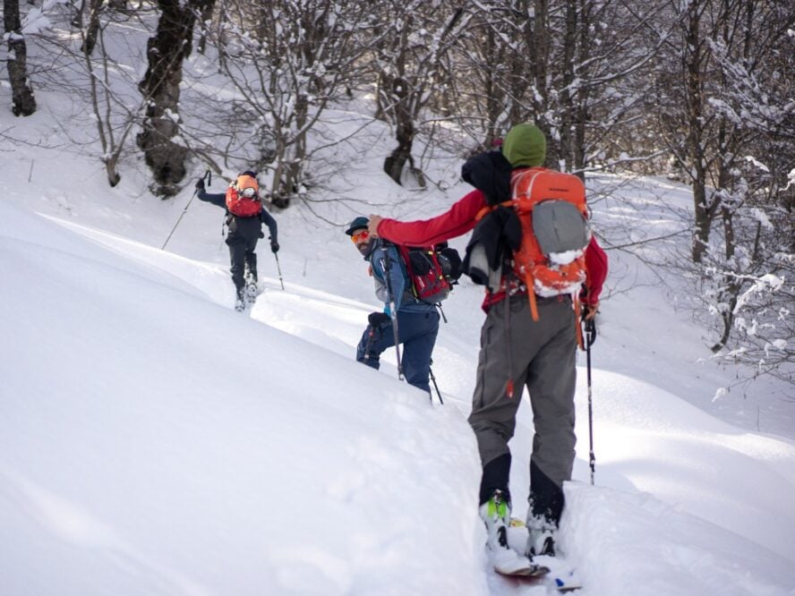 Three skiers on snowy mountains in Racha