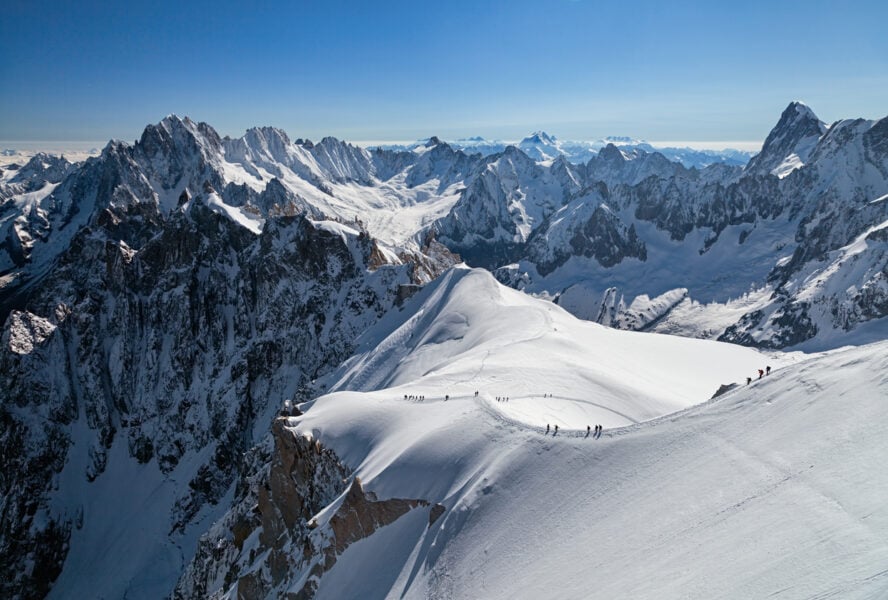 Mountaineers crossing snowy ridge in Chamonix Alps