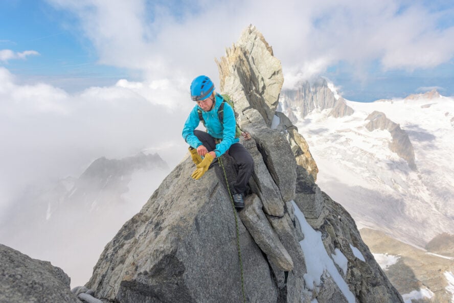 Woman mountaineer standing on the summit of Dent du Geant in the Alps