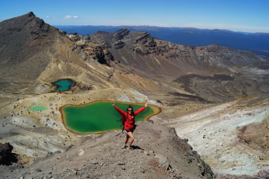A hiker posing in front of Emerald Lake on a New Zealand hiking trail