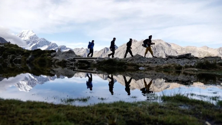 Hikers near a reflection of Mt. Cook in New Zealand